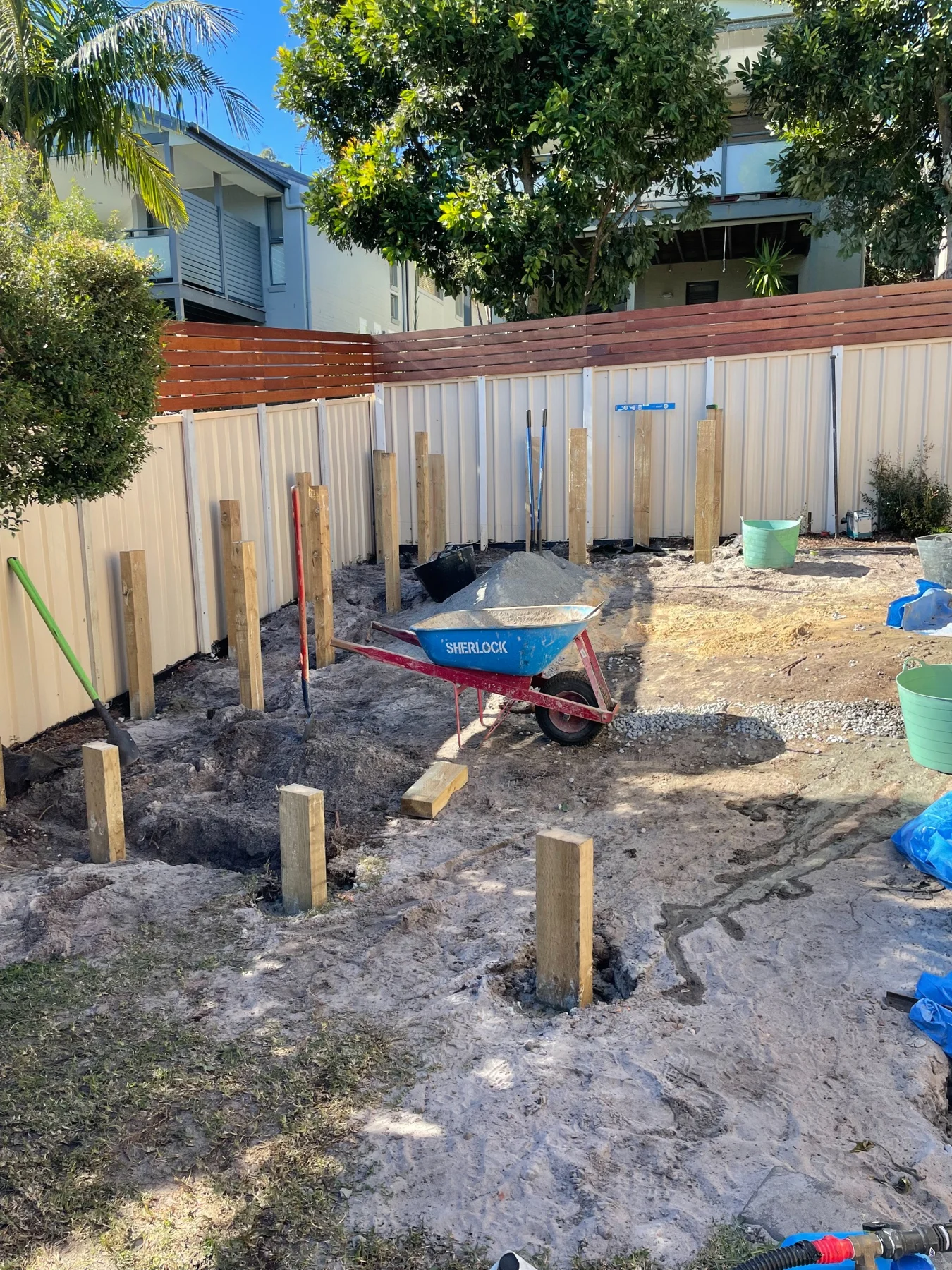 Early construction of the fire-pit seating area, showing posts and site preparation