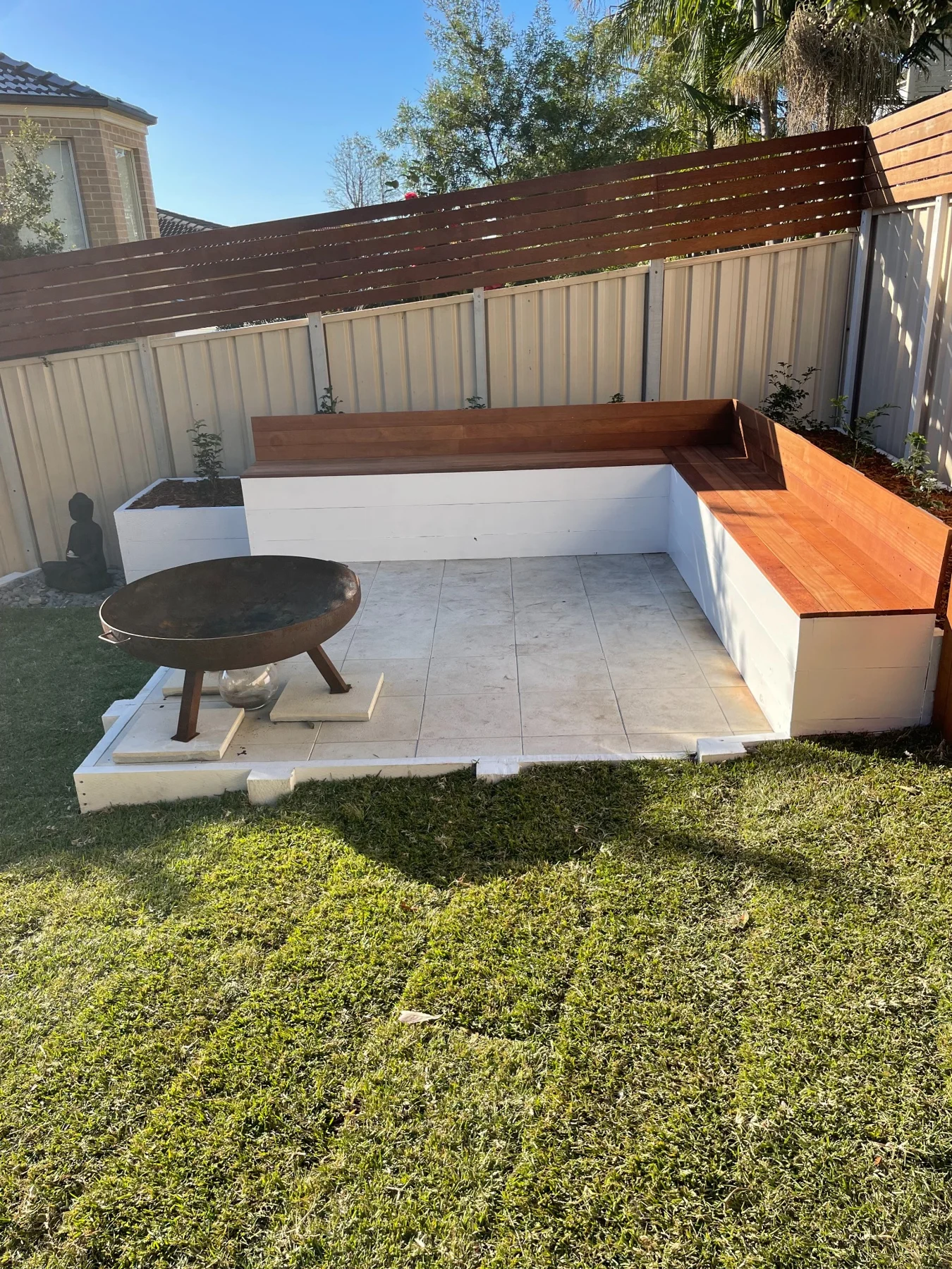 Finished timber seating, paving and fire pit in the same garden